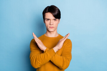 Photo of confident guy crossed hands show stop signal wear orange shirt isolated blue color...