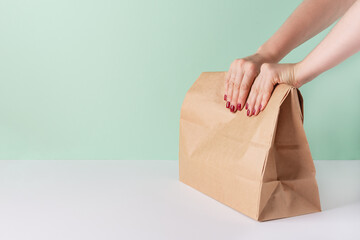 Woman hands holding paper bag with take away food.