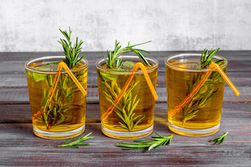 Fefreshing drink of cold tea and rosemary herbs in glasses