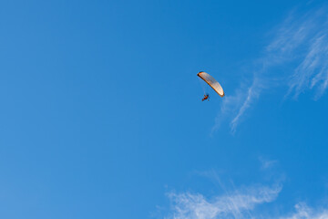 A powered paraglider trike flying over blue sky down up view