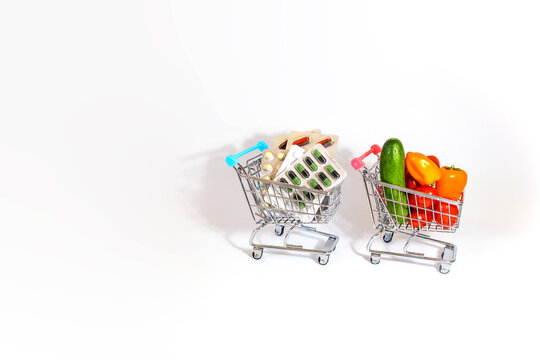 A Pair Of Supermarket Carts Containing Food And Medicine. The Concept Of Not Having Enough Money For Basic Necessities.