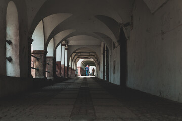 arcade passageway in small town, walking people seen from behind