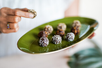 raw vegan chocolate energy balls as healthy fingerfood snack with nuts, cacao, marble syrup, dates,...