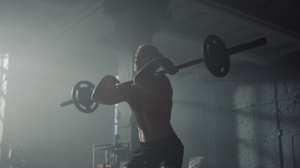 Male bodybuilder performing front squats with barbell. Man lifting weights 