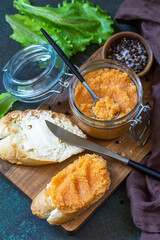 Sandwiches with butter and salted caviar on a dark stone countertop.