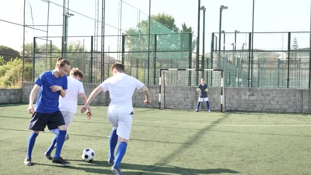 Junior football teams having golmouth scramble and struggling for ball