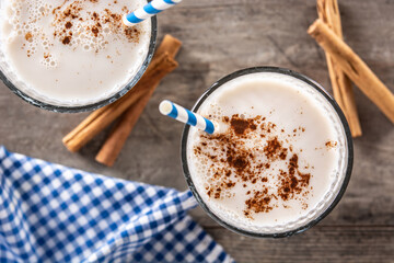Fresh horchata with cinnamon in glass on rustic wooden table. Top view