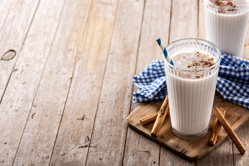 Fresh horchata with cinnamon in glass on rustic wooden table. Copy space
