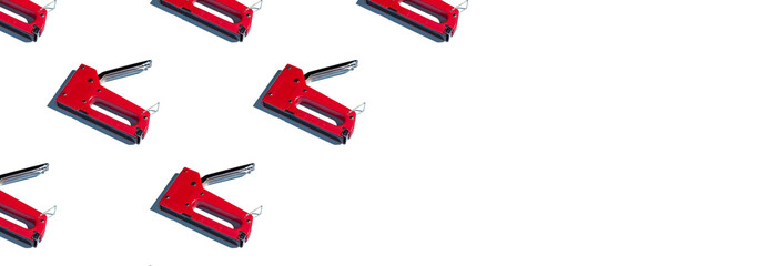 A pattern of construction staplers, copyspace on a white background. Construction tools, repairs. Background for the design.