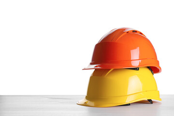 Different hard hats on wooden table against white background. Space for text