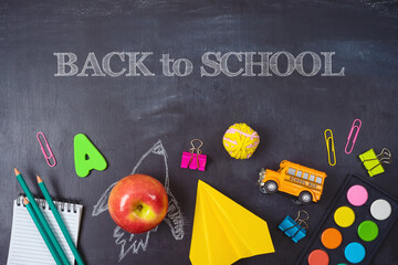 Back to school background with school supplies over chalkboard