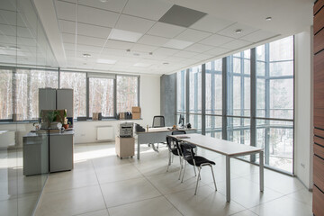 Image of empty modern office with chairs and desks in office building