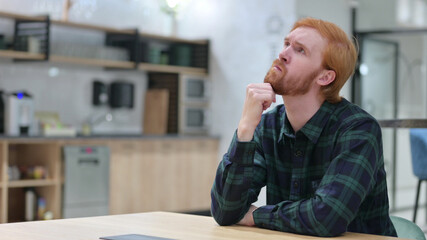 Pensive Redhead Man Sitting and Thinking 