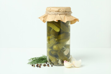 Jar of pickles and ingredients on white background