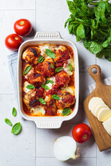 Italian cuisine concept. Roasted chicken in tomato sauce with mozzarella and basil.