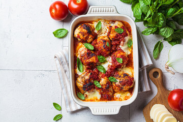 Italian cuisine concept. Roasted chicken in tomato sauce with mozzarella and basil.