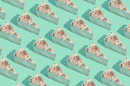 Creative pattern made of piece of pistachio cheesecake on pastel mint background. Healthy dessert concept. Minimal style