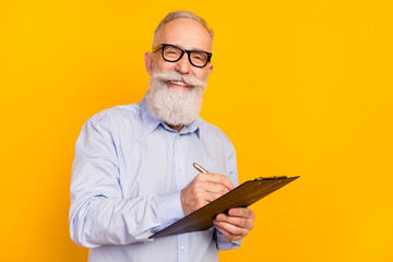 Portrait of attractive cheerful man writing notes strategy project development isolated over gray...