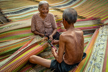Top view of old Vietnamese lover craftsman making the traditional vietnam mats with happiness...