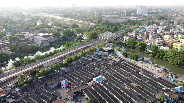 An aerial view of slums of India with rail track and bridge at a distance in HD