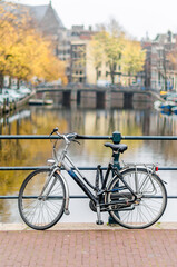 Typical urban scene in Amsterdam, the Netherlands with bicycles on a bridge over the canal