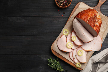 Delicious cut ham with spices served on black wooden table, flat lay. Space for text
