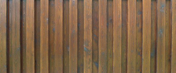 A new brown wooden fence made of planks.