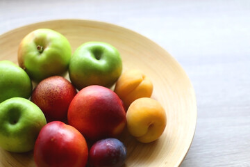 Wooden bowl with various colorful fruit. Selective focus.