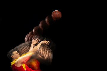 Professional basketball player training with ball isolated on dark background with stroboscope...