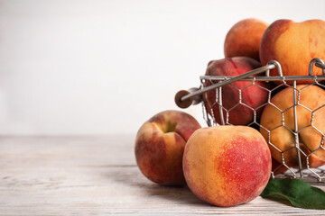 Fresh ripe juicy peaches on white wooden table, closeup. Space for text