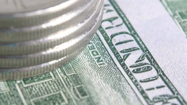 Stack of United Arab Emirates coins against the background of US hundred dollar bills. Pegged exchange rate concept. Macro view. Rotating money background. UAE money on american dollars. UAE exchange.