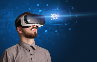 Businessman looking through Virtual Reality glasses, social media concept