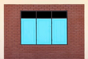 Blue wooden windows and dark brown brick block walls