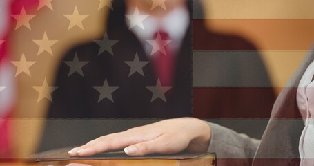 American flag design against mid section of woman taking an oath in the court room