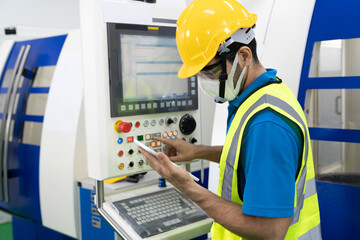 Caucasian technician use tablet to control cutting machines