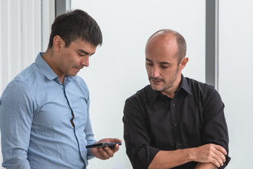 Two people looking on smartphone to trading online