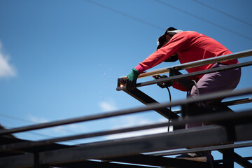 Worker welding the roof steel in construction site, Close up.