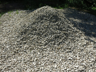 pile of small rubble, gravel lies on the road, an industrial background