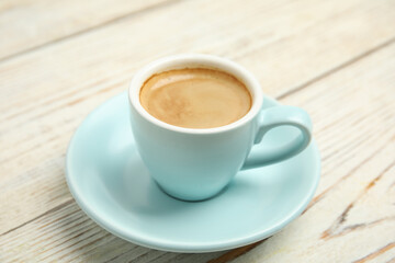 Cup of tasty coffee on white wooden table, closeup