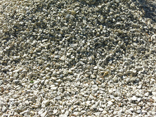 pile of small rubble, gravel lies on the road, an industrial background