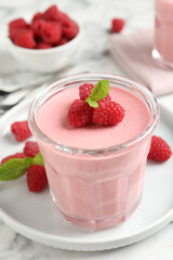 Delicious raspberry mousse with mint on white marble table