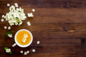 Jasmine flowers with green tea in a cup. Overhead view