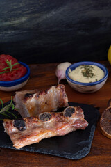 Freshly cooked roast pork ribs with garnish. Food concept with various salads with tomato and mayonnaise.

