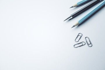 Close up of pencils and paper clips on white mockup desk backdrop, Stationery concept. 3D Rendering.