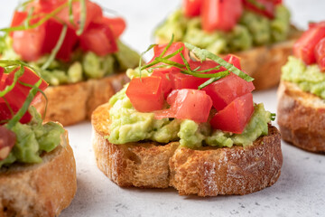 avocado and tomato crostini. Bruschetta toast with mashed avocado