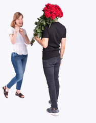 The handsome girl is glad to see her boyfriend carrying a beautiful bouquet of her favorite flowers.