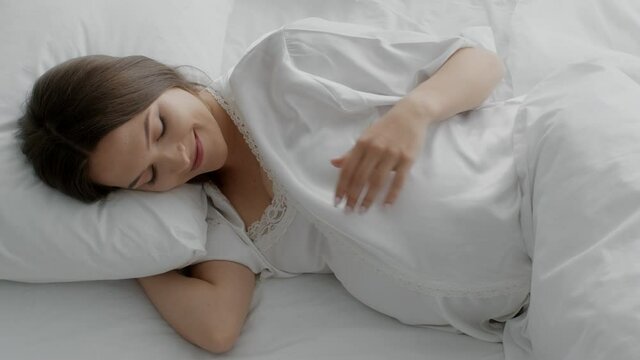Beautiful Pregnant Woman Lying In Bed And Tenderly Touching Her Belly