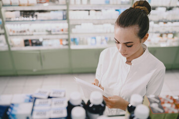 Woman pharmacist checking medicine in pharmacy