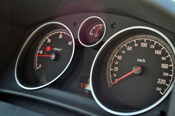 Close-up view of red speedometer hands in a car