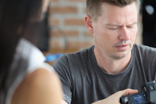 Male Photographer Is Looking At Camera Screen With Concentration